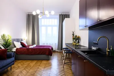 a room with a kitchen and a bedroom with a bed at Unique Style Apartments Old Town - 25 min from the airport - by Homelike Krakow in Kraków