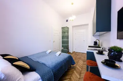 a small bedroom with a bed and a kitchen at Unique Style Apartments Old Town - 25 min from the airport - by Homelike Krakow in Kraków