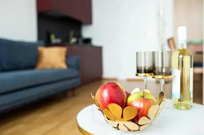 a bowl of apples on a table with a bottle of wine at Unique Style Apartments Old Town - 25 min from the airport - by Homelike Krakow in Kraków