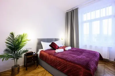 a bedroom with a bed with a purple comforter and a plant at Unique Style Apartments Old Town - 25 min from the airport - by Homelike Krakow in Kraków