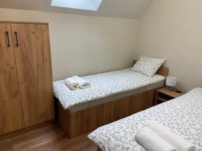 a small bedroom with two beds and a wooden cabinet at 3 JASKÓŁKI in Kasina Wielka