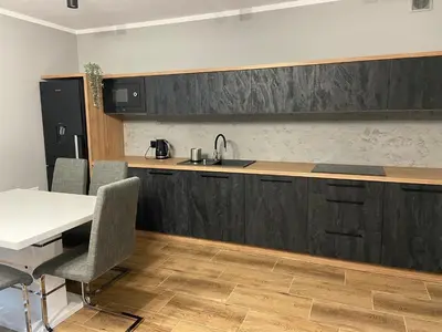 a kitchen with a counter and a table and chairs at 3 JASKÓŁKI in Kasina Wielka