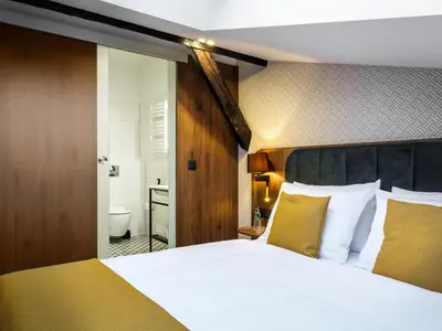 a bedroom with a large bed and a bathroom at Old Market Residence in Kraków