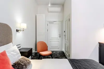 a hotel room with a bed and a chair at N33 Premium Apartments Old Town Kraków - Destigo Hotels in Kraków