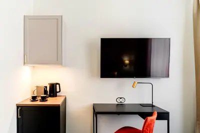 a room with a desk and a tv on the wall at N33 Premium Apartments Old Town Kraków - Destigo Hotels in Kraków