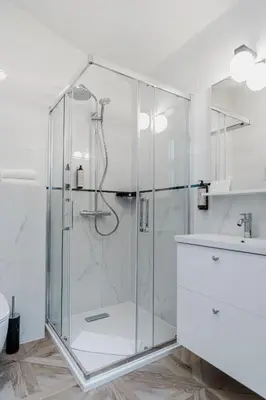 a shower with a glass door in a bathroom at N33 Premium Apartments Old Town Kraków - Destigo Hotels in Kraków