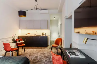 a living room with a table and chairs and a kitchen at N33 Premium Apartments Old Town Kraków - Destigo Hotels in Kraków