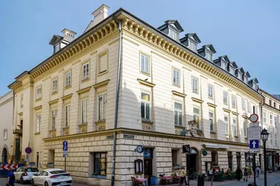 a large white building on the corner of a street at N33 Premium Apartments Old Town Kraków - Destigo Hotels in Kraków