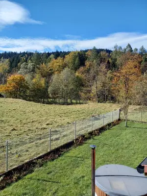 a fence in front of a field with trees at Agroturystyka Yvonne in Zawoja
