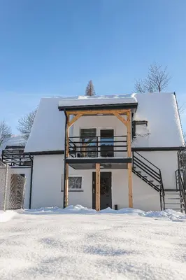 a house with snow on the ground in front of it at Agroturystyka Yvonne in Zawoja
