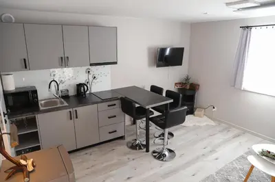 a kitchen with white cabinets and a table and chairs at Agroturystyka Yvonne in Zawoja