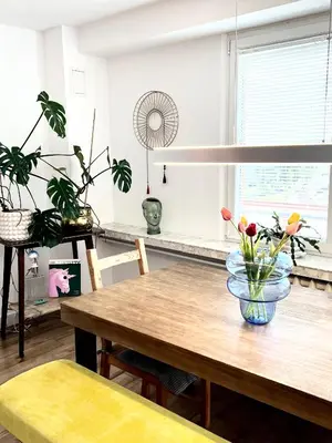 a dining room table with a vase of flowers on it at Designer Loft 60m sq in Cracow Center Sunny Top-Floor Apartment with Balcony, King Bed & Great Transport in Kraków