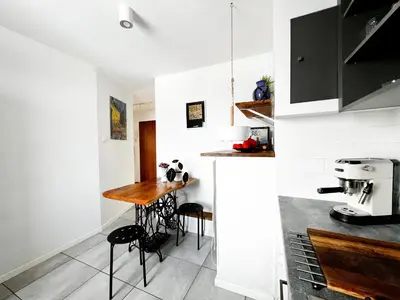 a kitchen with a counter and a table in it at Designer Loft 60m sq in Cracow Center Sunny Top-Floor Apartment with Balcony, King Bed & Great Transport in Kraków