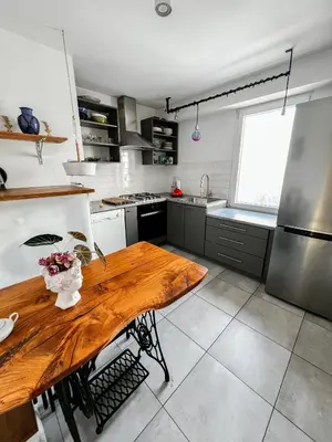 a kitchen with a wooden table in the middle at Designer Loft 60m sq in Cracow Center Sunny Top-Floor Apartment with Balcony, King Bed & Great Transport in Kraków