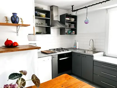 a kitchen with black and white cabinets and a sink at Designer Loft 60m sq in Cracow Center Sunny Top-Floor Apartment with Balcony, King Bed & Great Transport in Kraków