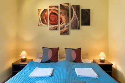 a bedroom with a blue bed with three paintings on the wall at Big Cosy RETRO Apt, FREE PARKING, 15min OldTown & Kazimierz - by Homelike Krakow in Kraków