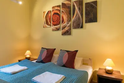 a bedroom with two beds and paintings on the wall at Big Cosy RETRO Apt, FREE PARKING, 15min OldTown & Kazimierz - by Homelike Krakow in Kraków