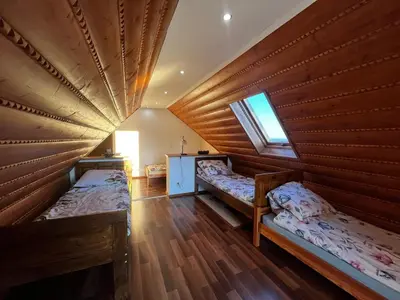 a room with two beds in a wooden house at Noclegi Gal in Odrowąż