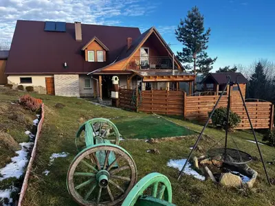 a large home with a wooden house with a wheel at Noclegi Gal in Odrowąż