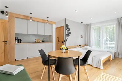 a bedroom with a bed and a table and chairs at Przy Szlaku in Zawoja