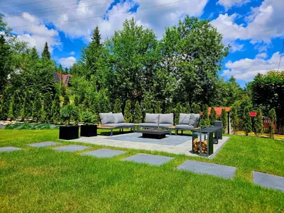 a patio with two couches and a table in a yard at Przy Szlaku in Zawoja