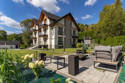 a house with a patio and a lawn at Przy Szlaku in Zawoja