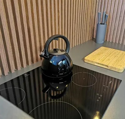 a black tea kettle sitting on top of a stove at Apartament Raciborska 1 in Kraków