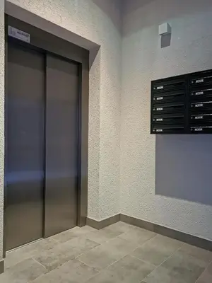 two elevator doors in a room with a tile floor at Apartament Raciborska 1 in Kraków