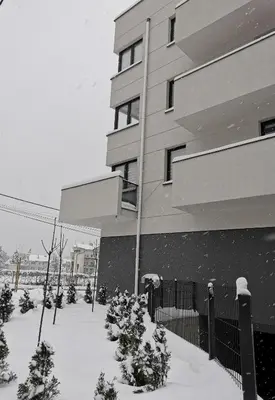 a building with snow on the ground in front of it at Apartament Raciborska 1 in Kraków