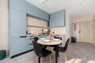 a kitchen and dining room with a table and chairs at Świtezianki Luxurious Apartments with Parking by Renters Prestige in Kraków