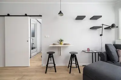 a living room with a couch and two bar stools at Świtezianki Luxurious Apartments with Parking by Renters Prestige in Kraków