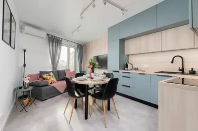 a kitchen and living room with a table and a couch at Świtezianki Luxurious Apartments with Parking by Renters Prestige in Kraków