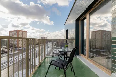 a balcony with a table and chairs on a balcony at Świtezianki Luxurious Apartments with Parking by Renters Prestige in Kraków