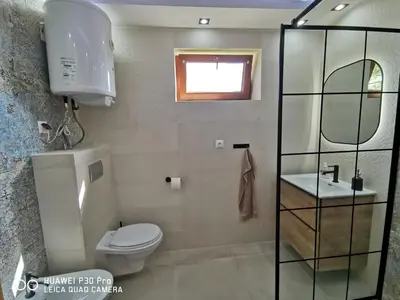 a bathroom with a toilet and a sink and a mirror at Domek na Niedźwiedziarce in Zawoja