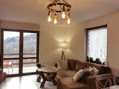 a living room with a couch and a table at Domek na Niedźwiedziarce in Zawoja