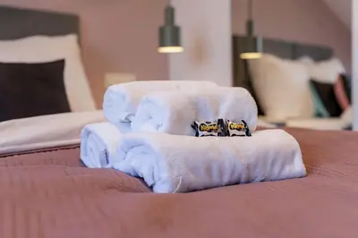 a bed with white towels on top of it at Wawel View Apartment in Kraków