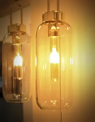 two glass lights are hanging from a wall at Wawel View Apartment in Kraków