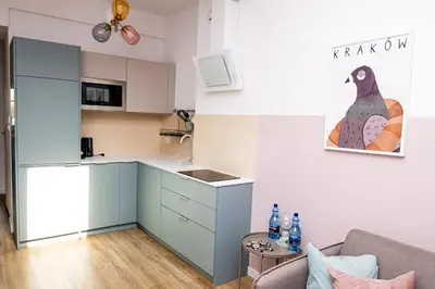 a kitchen with blue cabinets and a couch in a room at Wawel View Apartment in Kraków