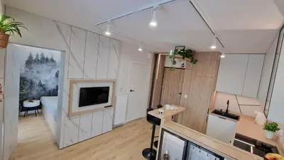 a living room with a television and a room with a couch at Magic House Apartament Proszowska 58 in Bochnia