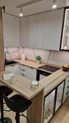 a kitchen with white cabinets and a wooden counter top at Magic House Apartament Proszowska 58 in Bochnia
