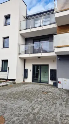 an empty parking lot in front of a white building at Magic House Apartament Proszowska 58 in Bochnia