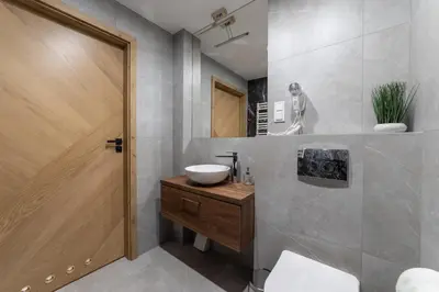 a bathroom with a sink and a wooden door at MILU Apartments Sebastiana in Kraków
