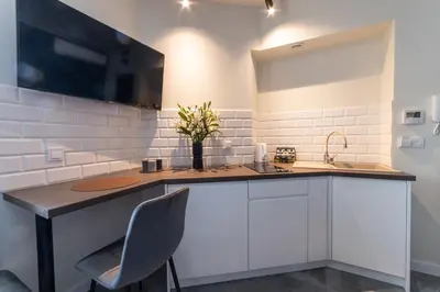 a kitchen with white cabinets and a sink at MILU Apartments Sebastiana in Kraków