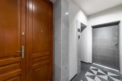 a bathroom with a wooden door and a walk in shower at MILU Apartments Sebastiana in Kraków