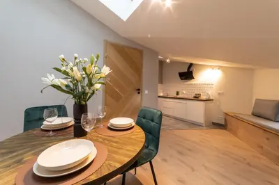 a dining room and kitchen with a table and chairs at MILU Apartments Sebastiana in Kraków