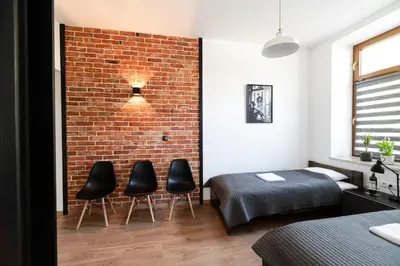 a bedroom with a brick wall and two chairs at NEO UNIQUE & BRIGHT Apartments, FREE PARKING, 15min Old Town & Kazimierz - by Homelike Krakow in Kraków