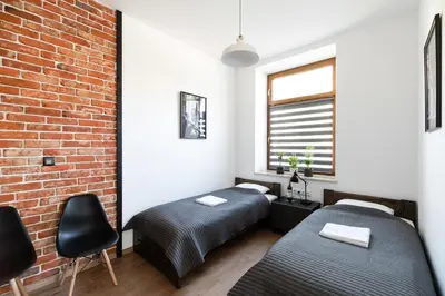 a bedroom with two beds and a brick wall at NEO UNIQUE & BRIGHT Apartments, FREE PARKING, 15min Old Town & Kazimierz - by Homelike Krakow in Kraków