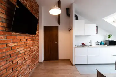 a kitchen with a brick wall and a door at NEO SKY Apartment, FREE PARKING, 15 min walk Old Town&Kazimierz - by Homelike Krakow in Kraków