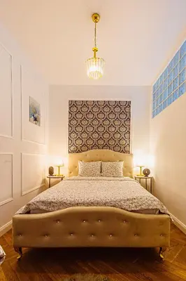 a bedroom with a large bed and a chandelier at Glamour Old Town Blich Kraków in Kraków