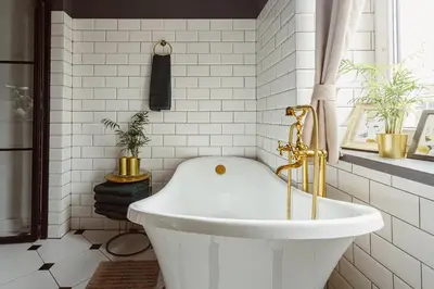 a bath tub in a bathroom with white tiles at Glamour Old Town Blich Kraków in Kraków